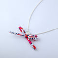 Load image into Gallery viewer, Silver necklace with a colorful bow and a Chapter One pendant