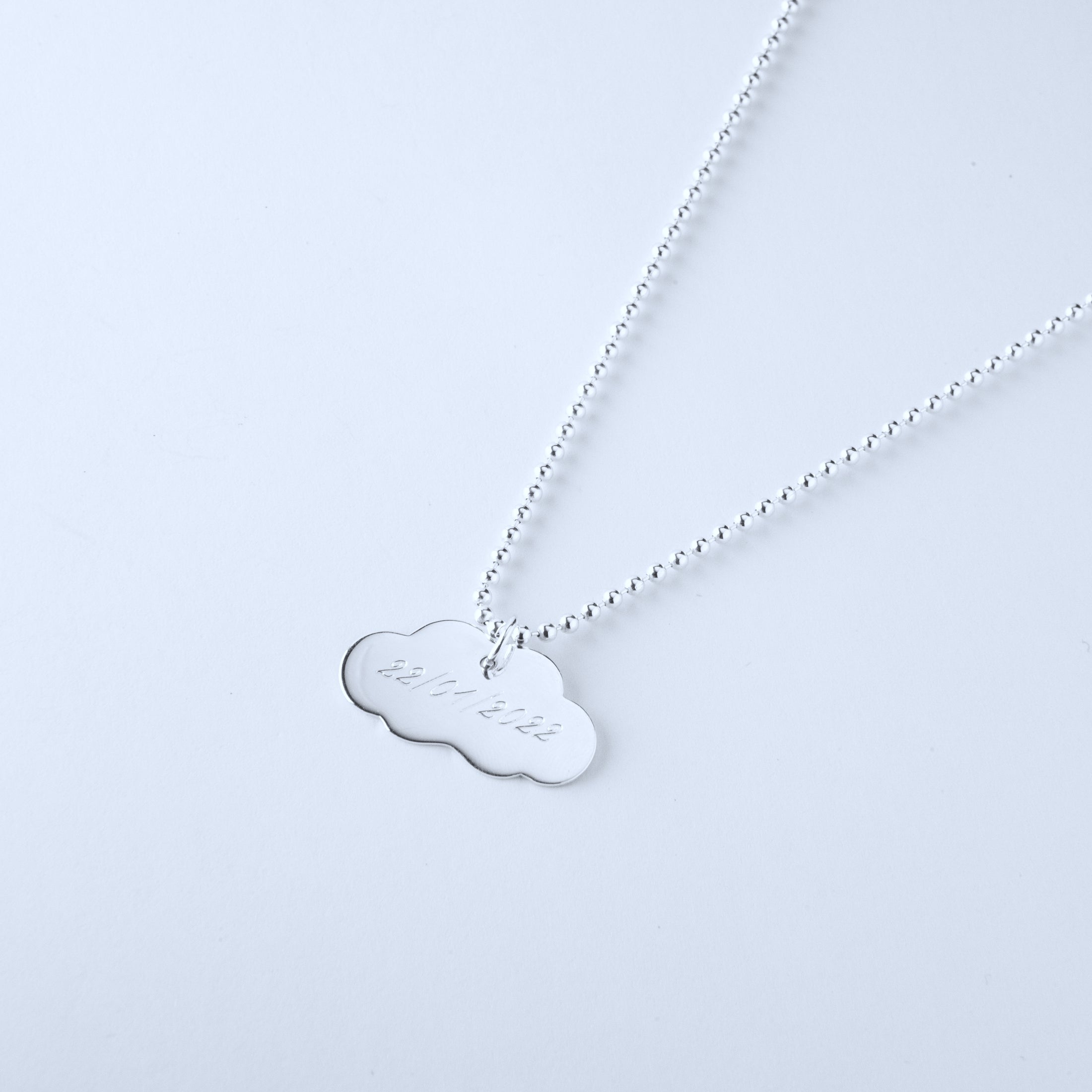 Silver necklace with a cloud-shaped pendant engraved with date