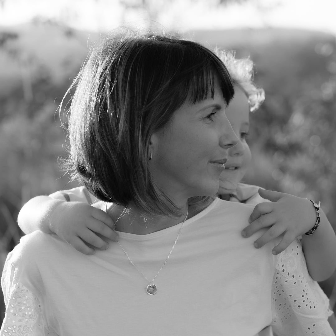 Mum wearing a sterling silver round pendant necklace engraved with initials