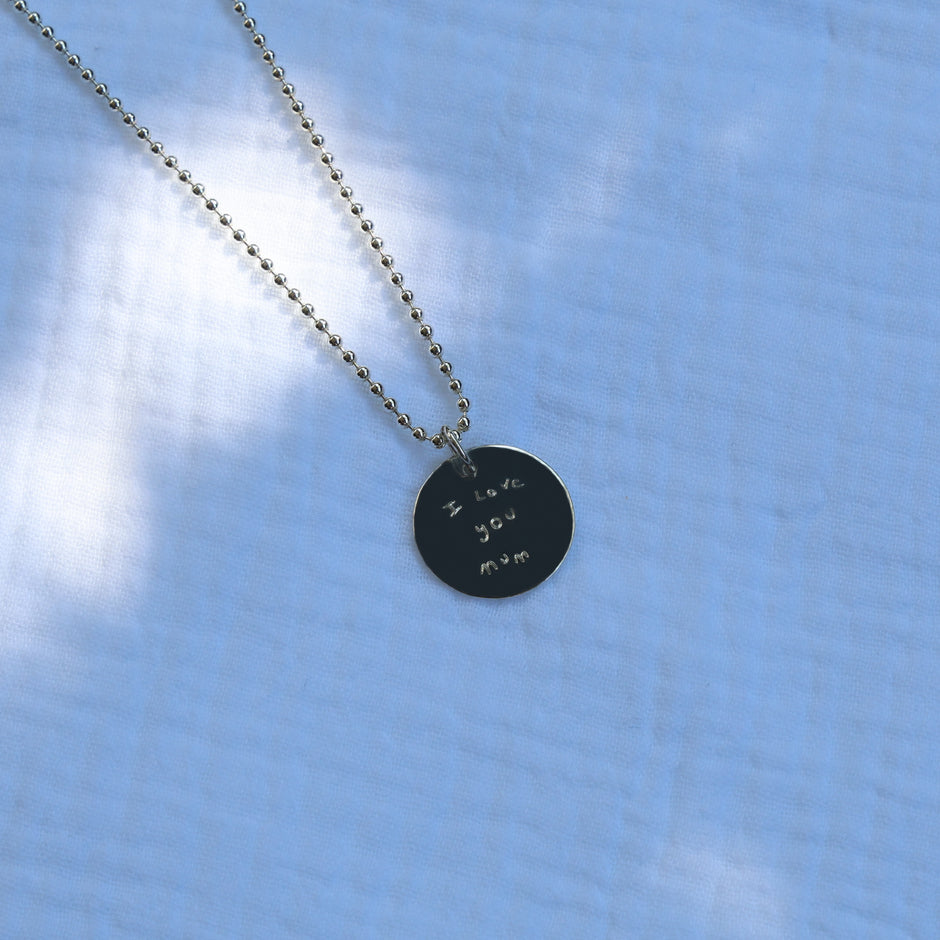 Handwritten message engrave on a silver necklace