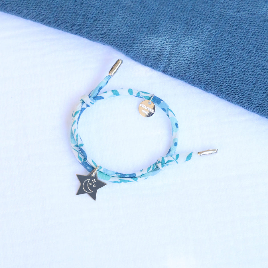 Blue floral-patterned bracelet with a star charm engraved with moon and stars