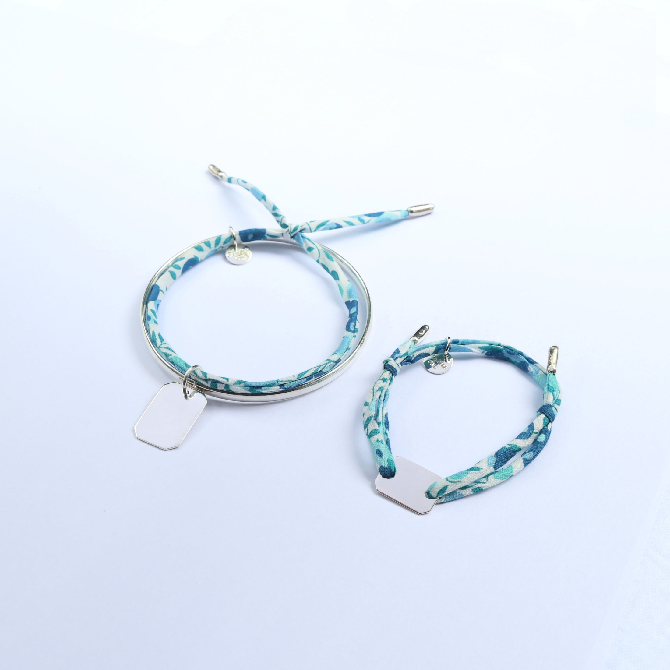 Mummy and me bracelets matching set, made of a silver bangle and a cord bracelet both with engravable bar pendants