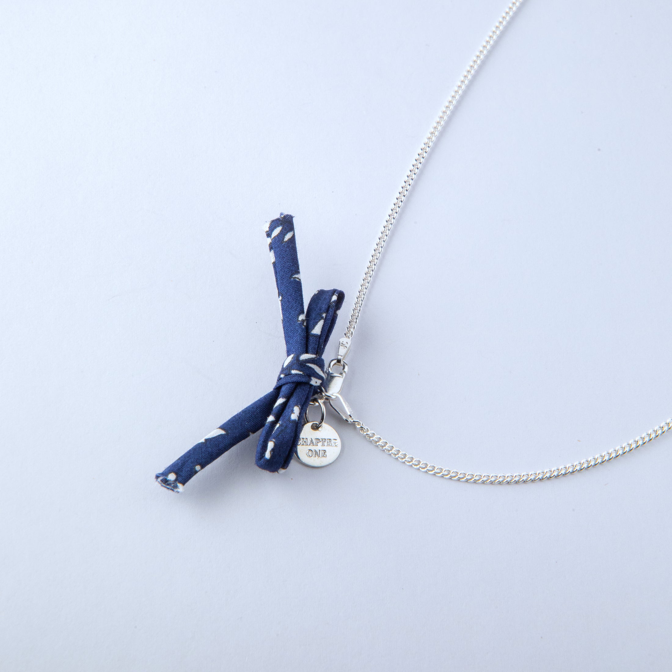 Necklace with blue fabric bow and silver chain 