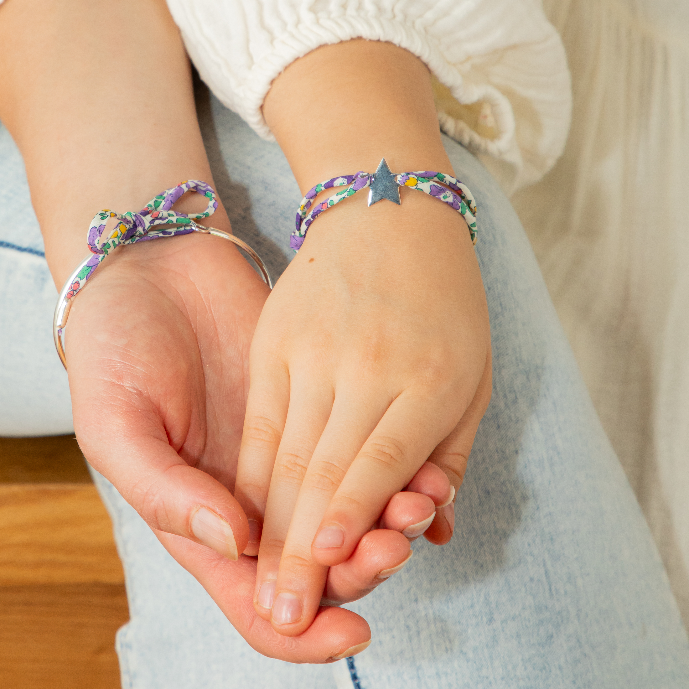Mother and child holding hands with matching bracelets
